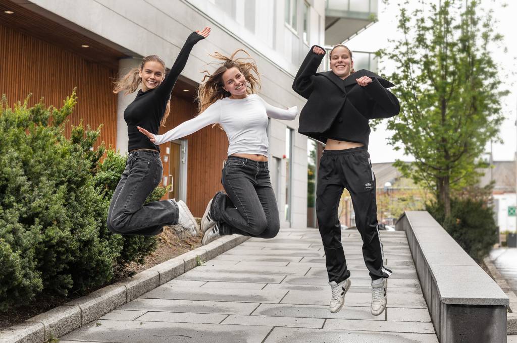 Tre unge kvinner som jubler og hopper i luften !''