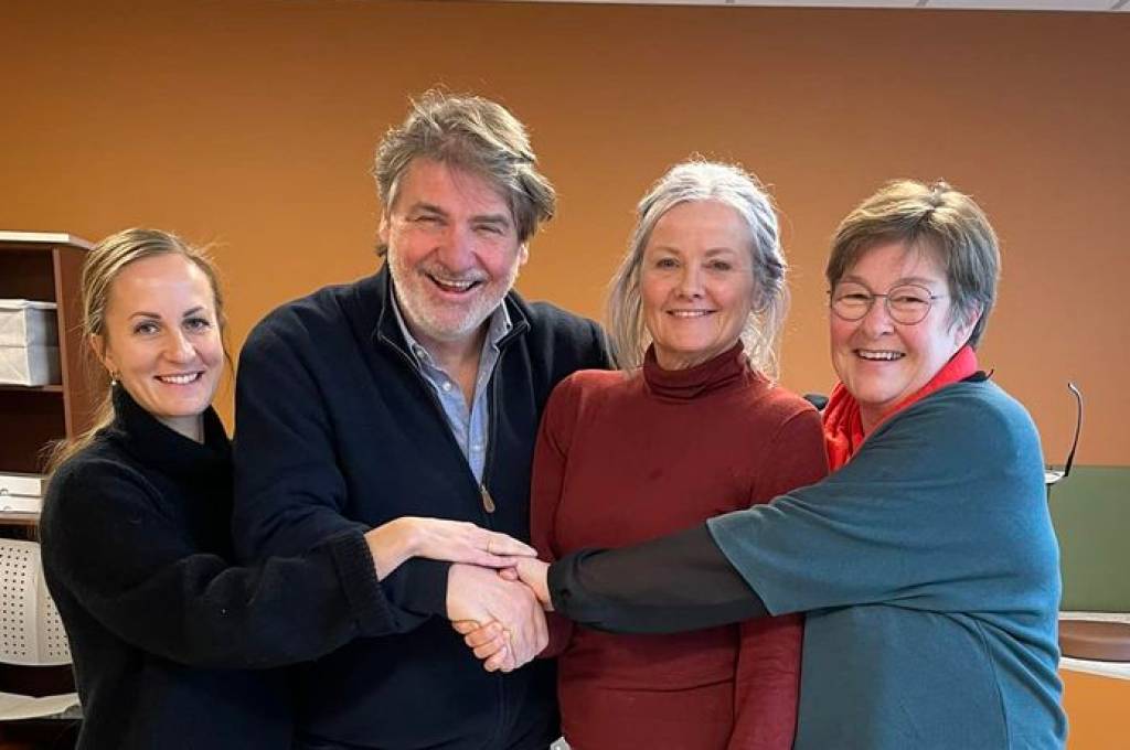 3 kvinner og en mann smilende, holder hender!''