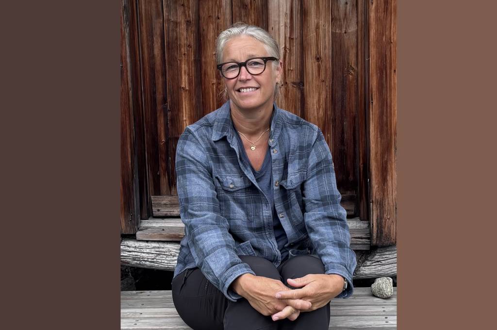 Lena Moland sitter smilende med hendene foldet på en gammel stabburstrapp.!''