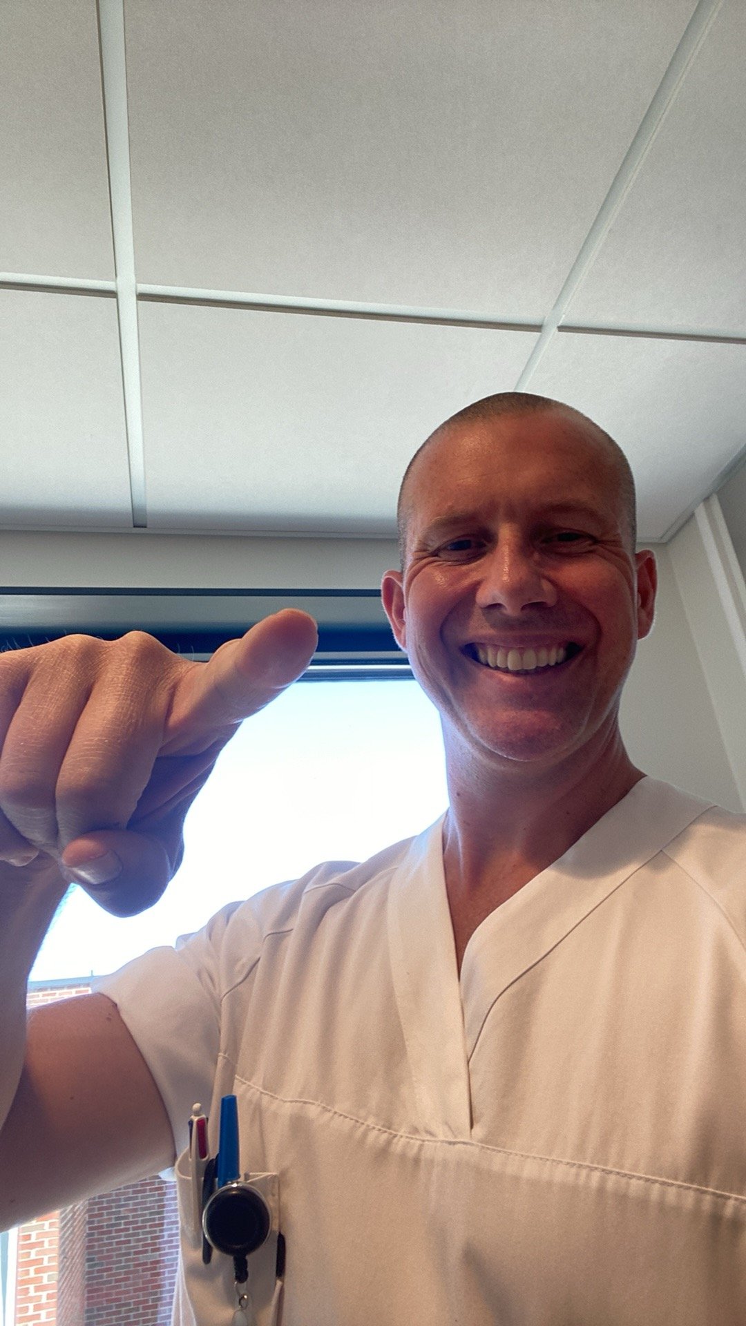 Nils Urdal ser i kamera og smiler og peker