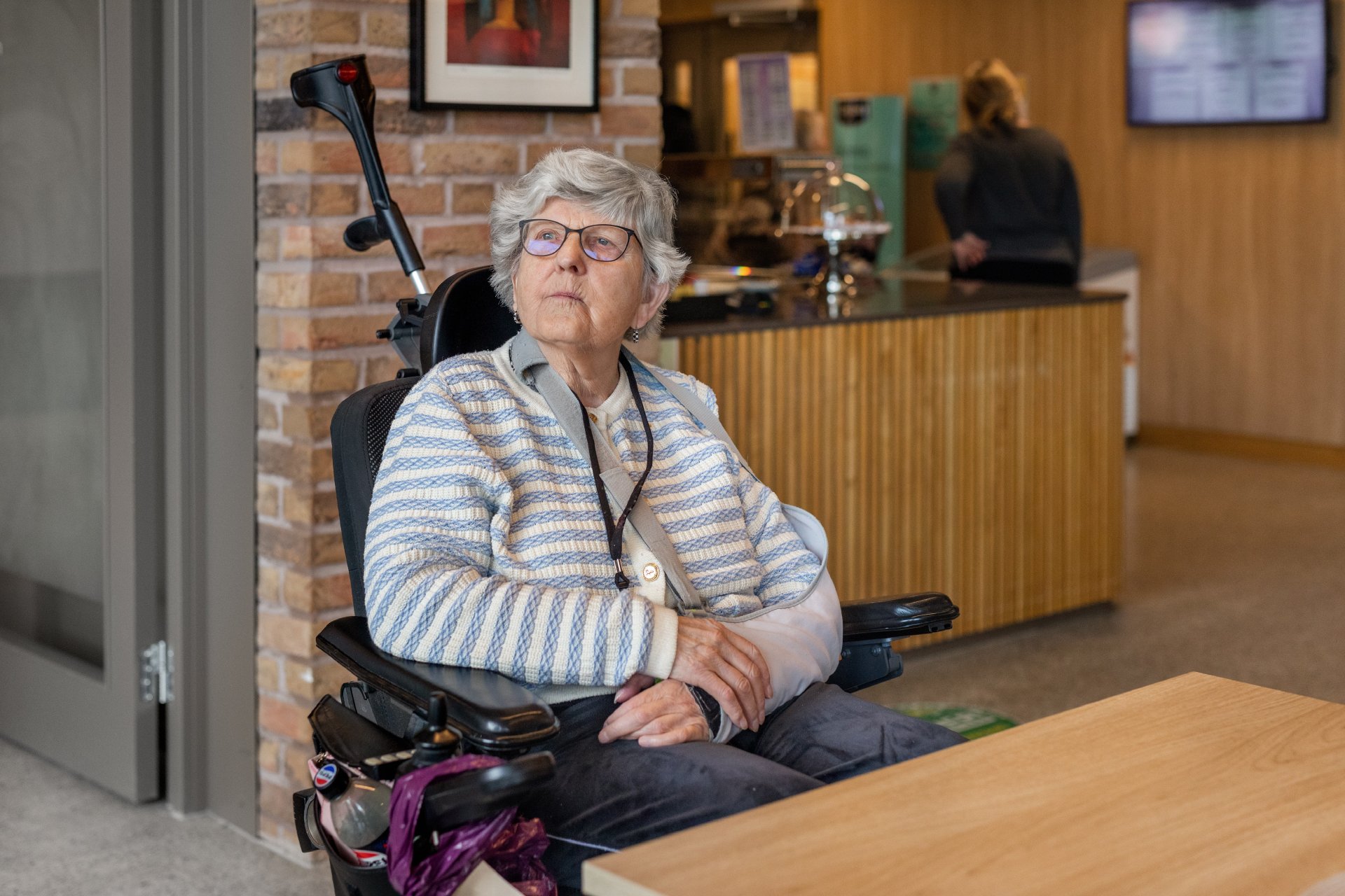 Eldre kvinne i rullestol som ser tenkende ut i luften