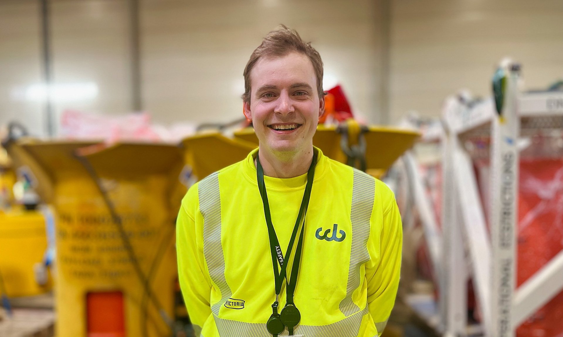 Stian Andersen i gul genser ser mot kamera og smiler