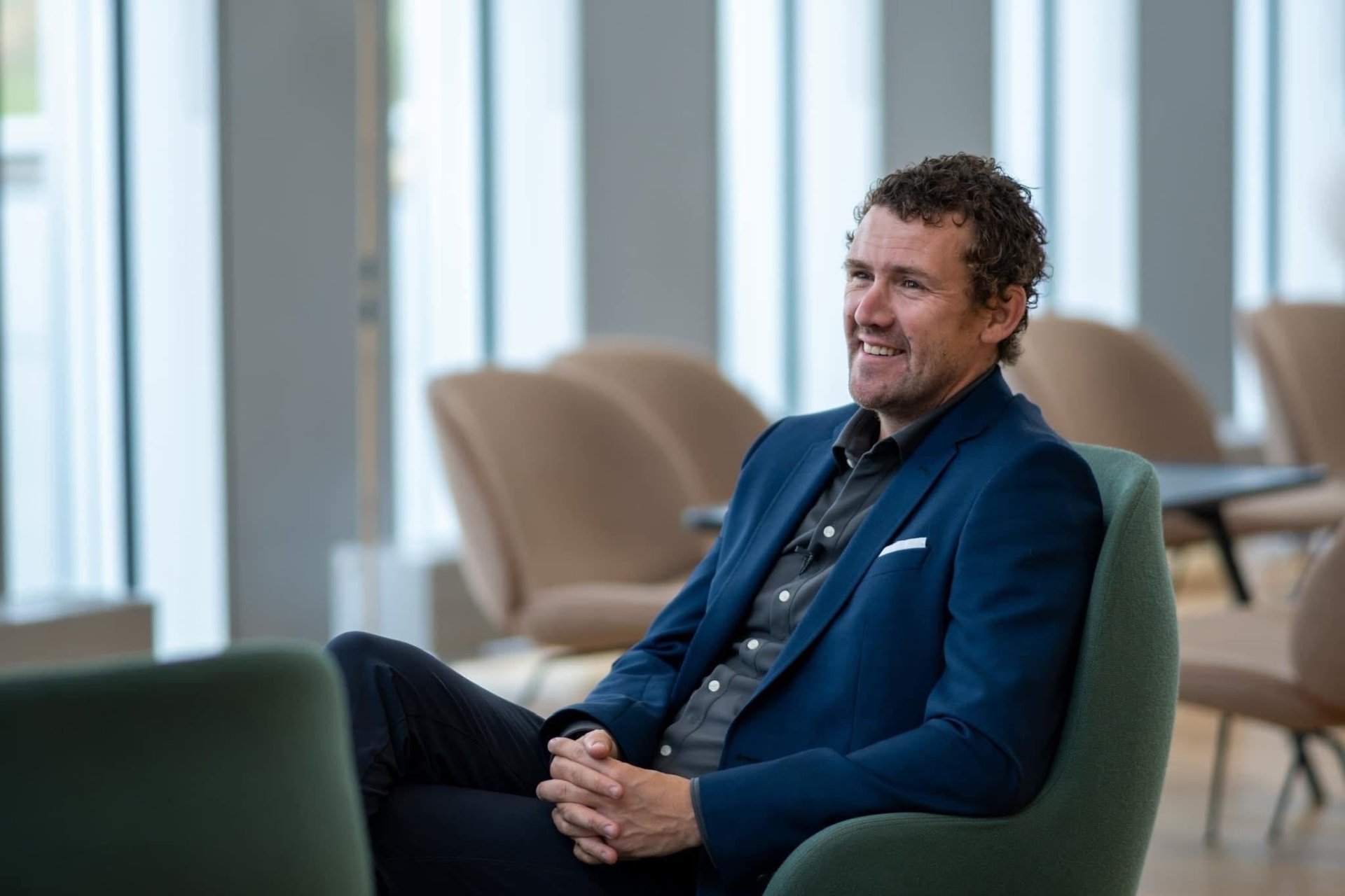 Psykologspesialist Jan Martin Berge sitter i en grønn stol og smiler