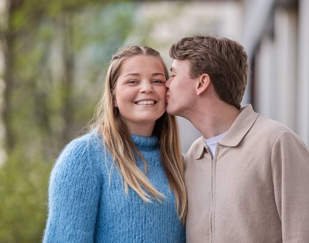 Et kjærestepar som viser omsorg hvor gutten kysser jenta på kinnet