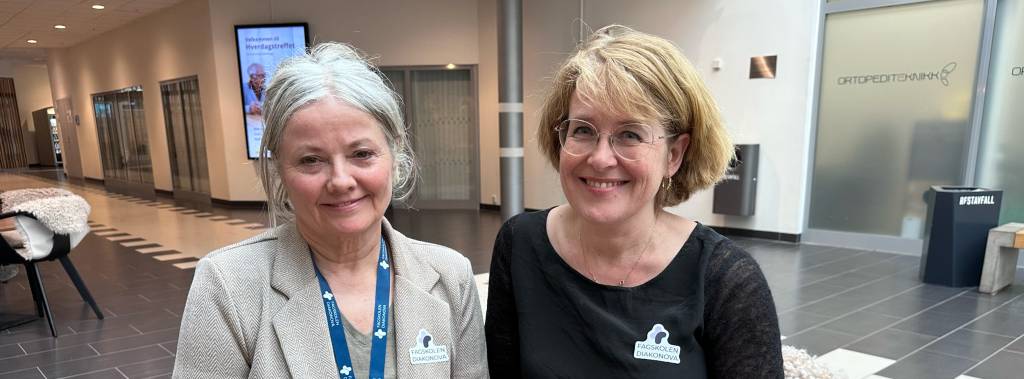 Tove Kittelsrud og Ingunn Fossaas sitter ved et bord og smiler fornøyd