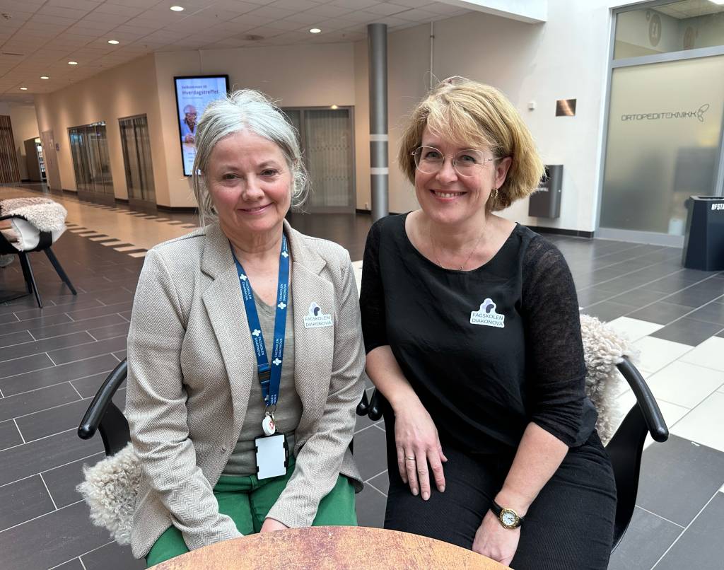 Tove Kittelsrud og Ingunn Fossaas sitter ved et bord og smiler fornøyd