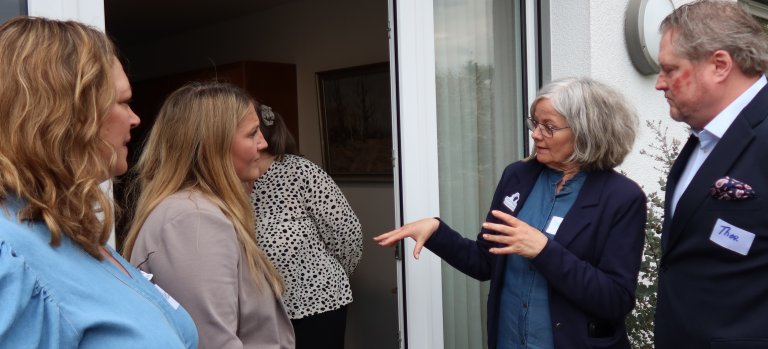 Representanter snakker sammen på verandaen til en av beboerne. 