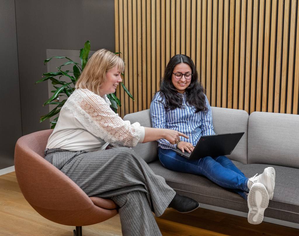 To kvinnelige studenter på Fagskolen Diakonova snakker og ser på en laptop