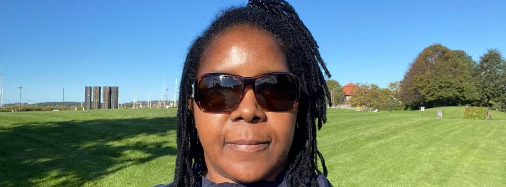 Selfie tatt av Noela med solbriller  og landskap i bakgrunnen