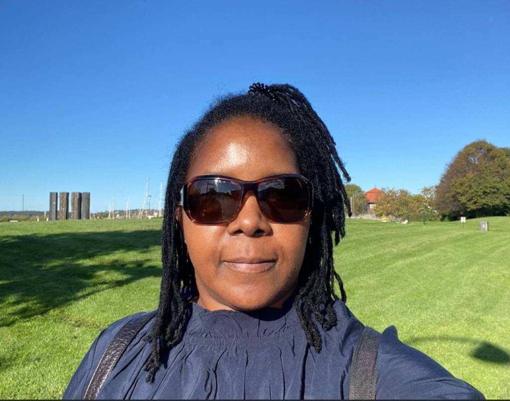 Selfie tatt av Noela med solbriller  og landskap i bakgrunnen