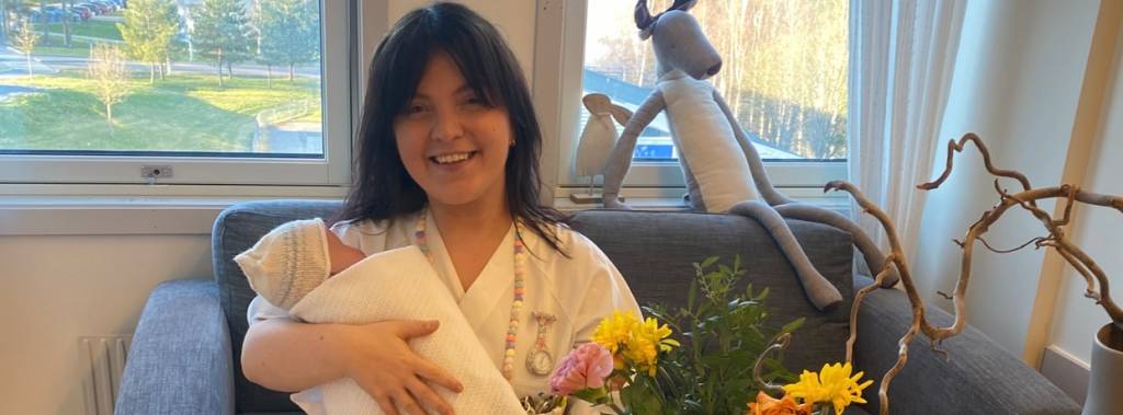 Kine på jobb på barselavdeling med en liten nyfødt baby