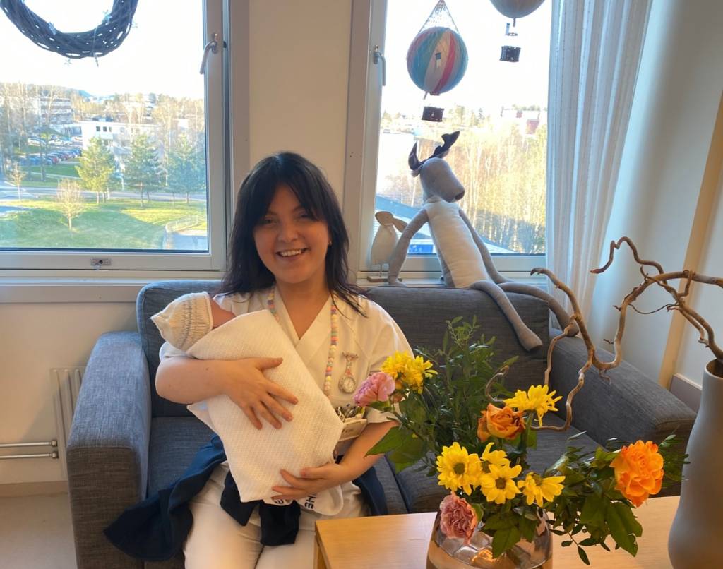 Kine på jobb på barselavdeling med en liten nyfødt baby