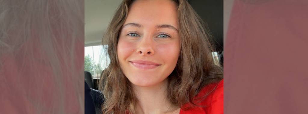 Elida Josefine Rognerud, student ved Fagskolen Diakonova, smiler i rød uniform.