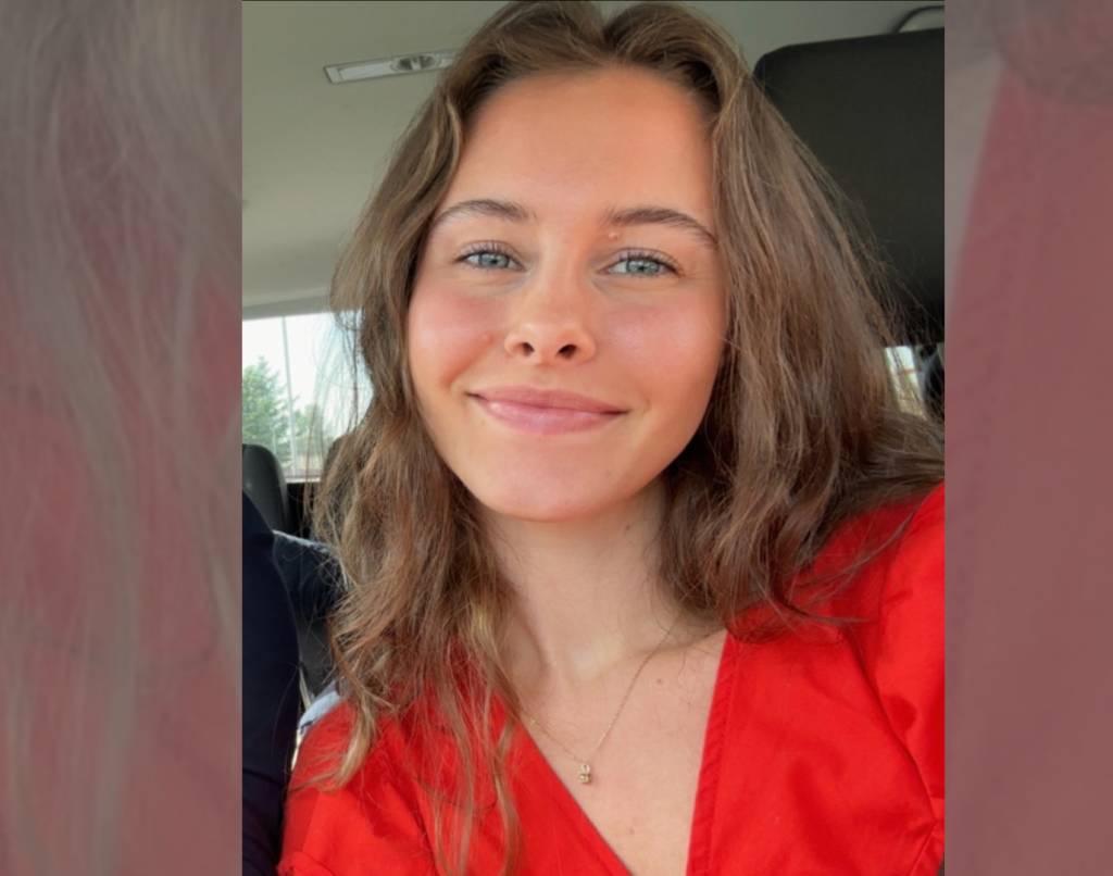Elida Josefine Rognerud, student ved Fagskolen Diakonova, smiler i rød uniform.