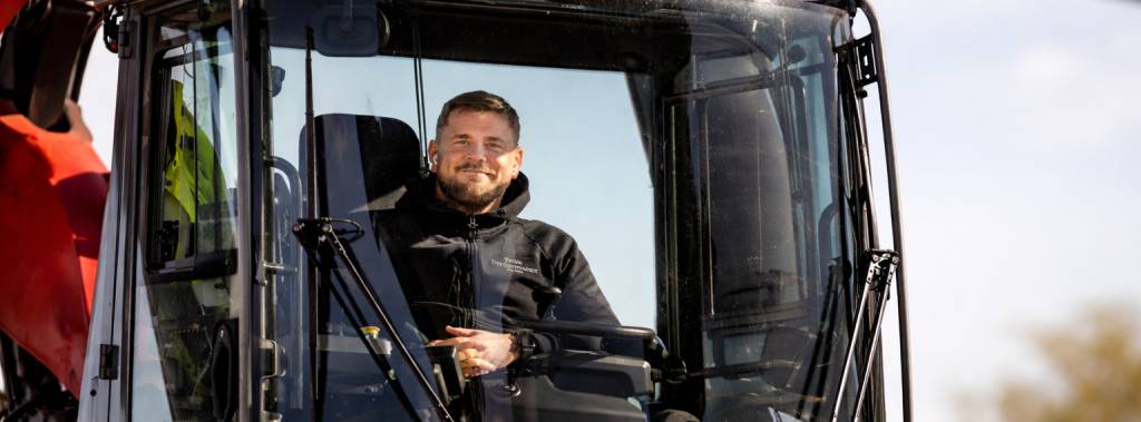 Mann som sitter i maskinhuset på en anleggsmaskin