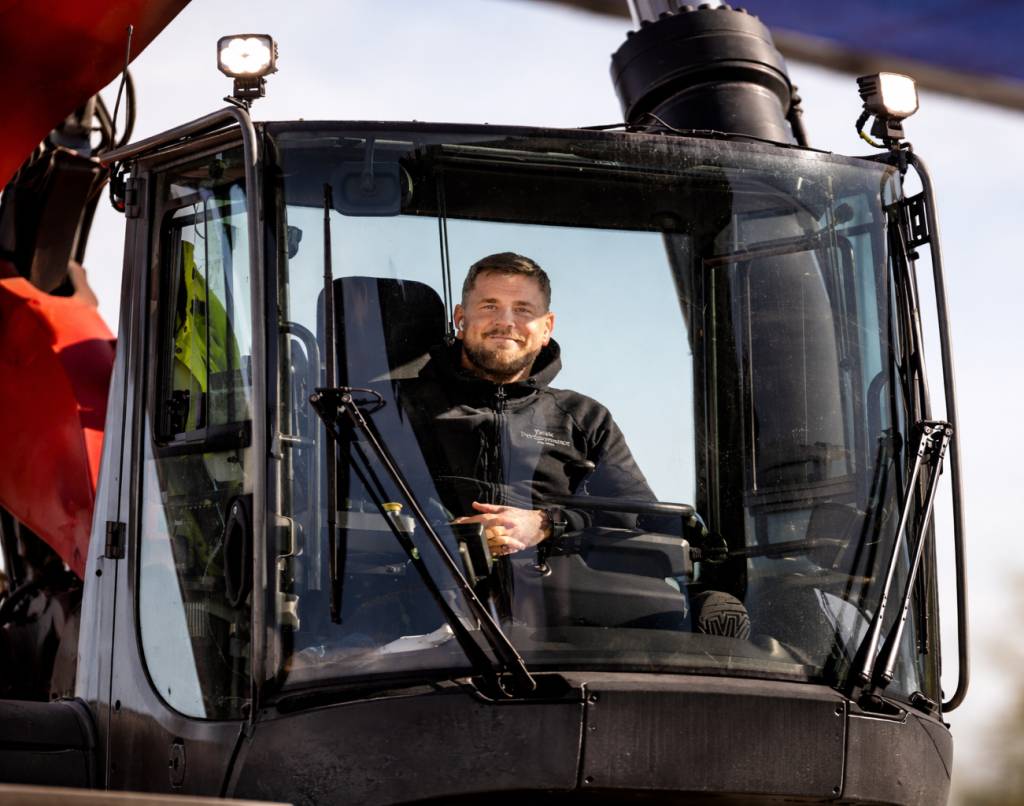 Mann som sitter i maskinhuset på en anleggsmaskin